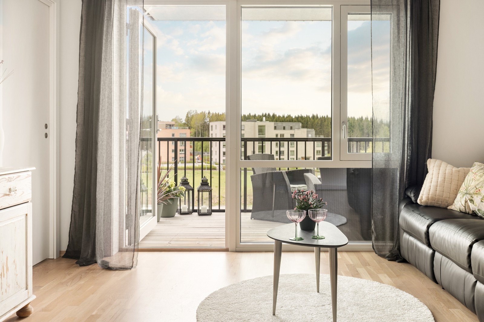 Store vindusflater og dør til balkongen gir rikelig med dagslys inn i leiligheten. Galleribilde