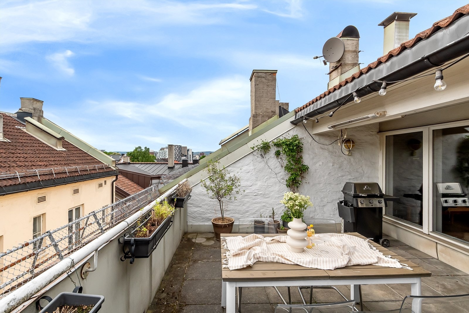 Flott felles takterrasse møblert med bord, stoler og gassgrill. Galleribilde