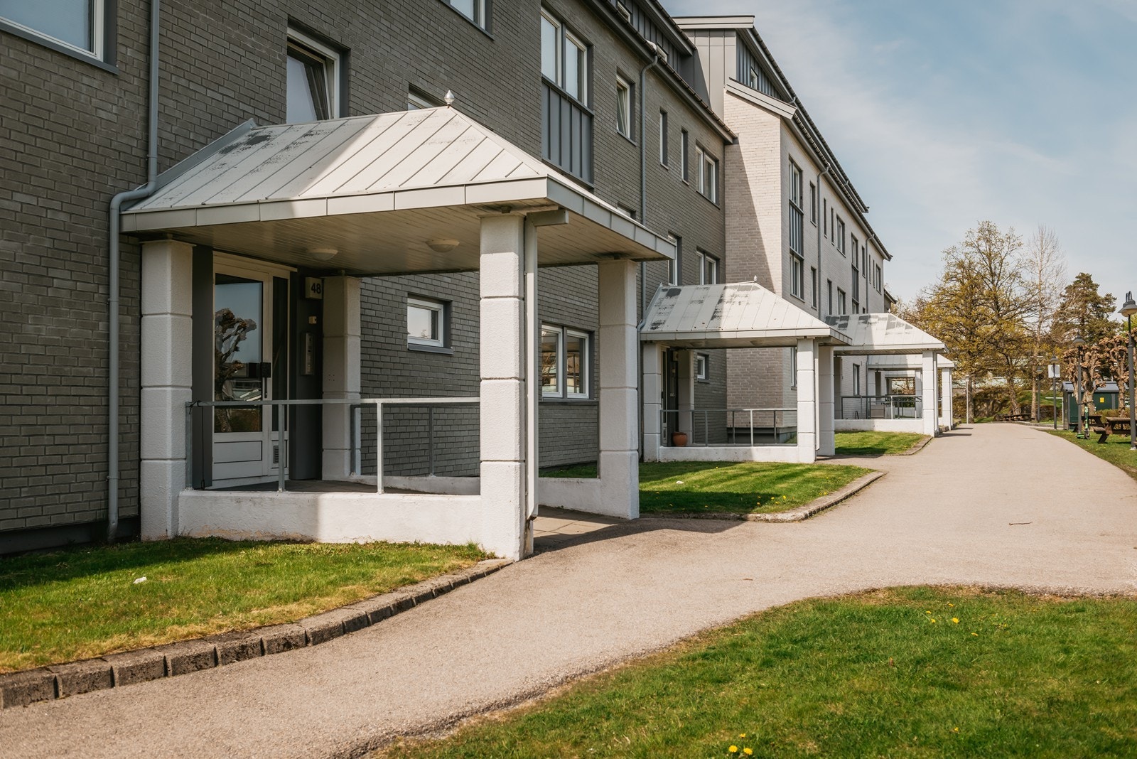 Eiendommen har en relativt flat tomt med plen og beplantning. Galleribilde