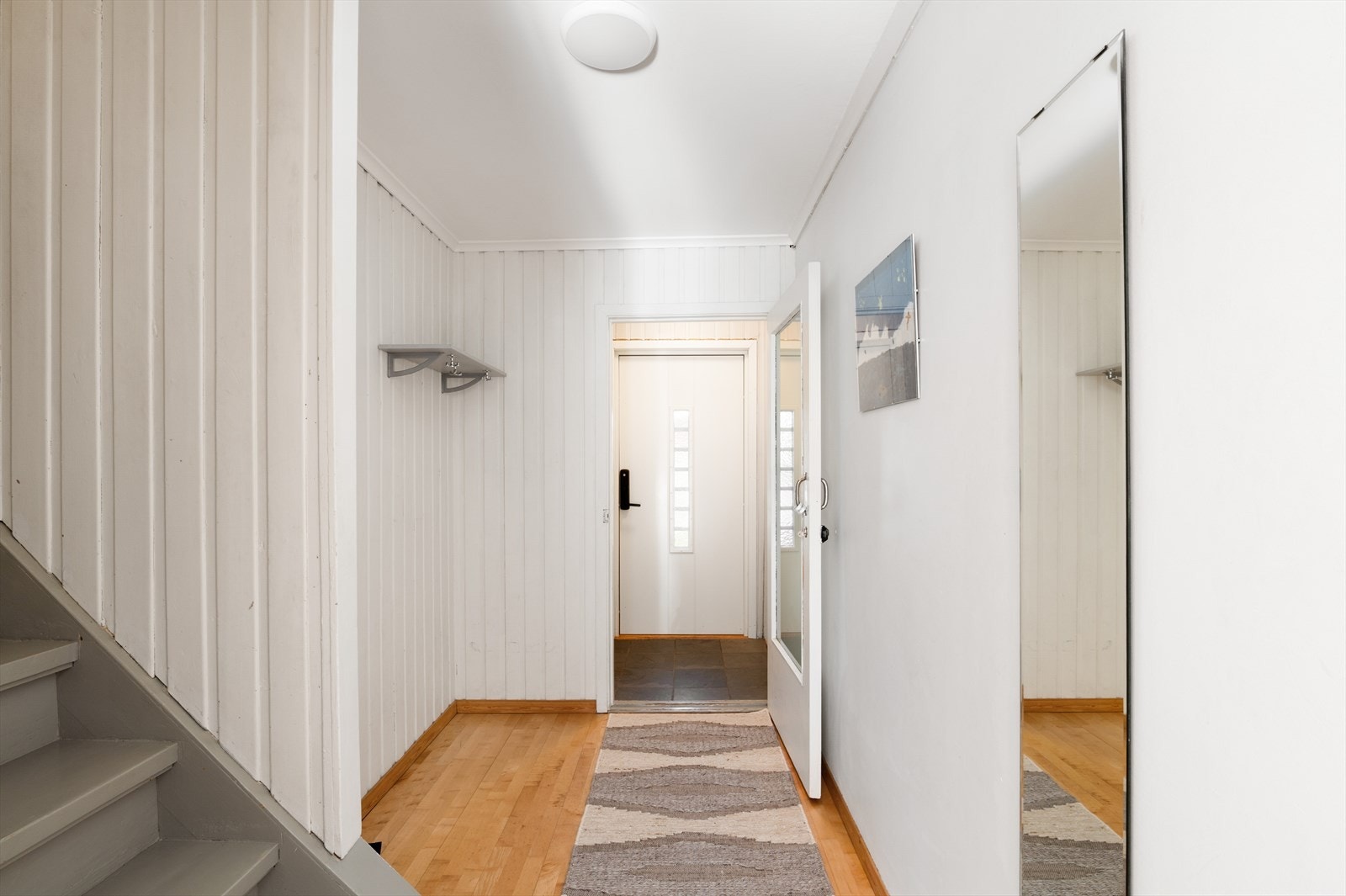Entré med trapp som binder etasjene sammen. Her er det plass til å henge fra seg yttertøy. Galleribilde