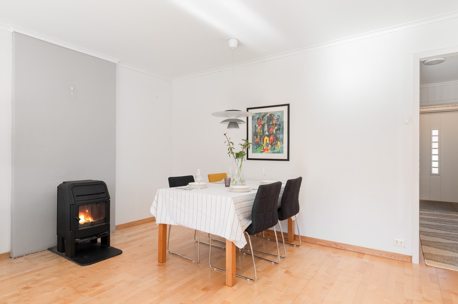 Spisestuen er plassert ved vedovnen, som gir en lun ramme rundt måltidene. Galleribilde