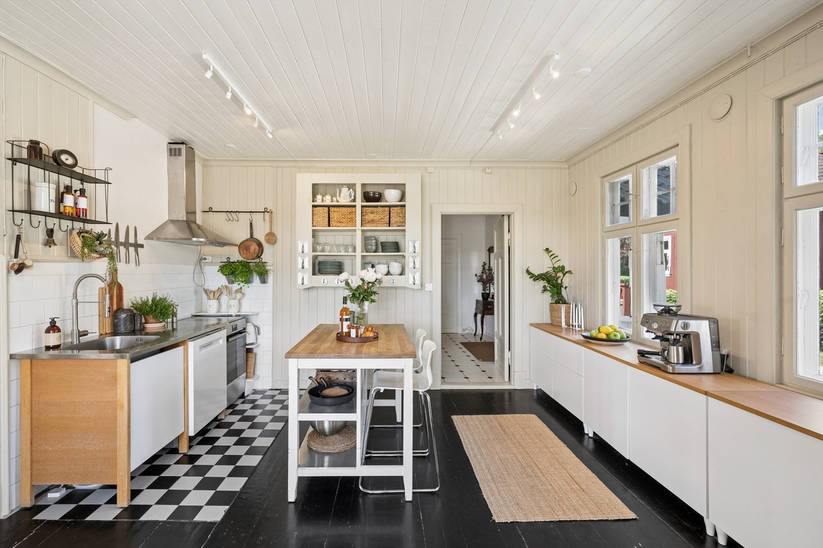 Kjøkkenet er romslig og funksjonelt, avlangt rom med tregulv og panel på både vegger og himling, noe som gir en lun og helhetlig atmosfære. Galleribilde