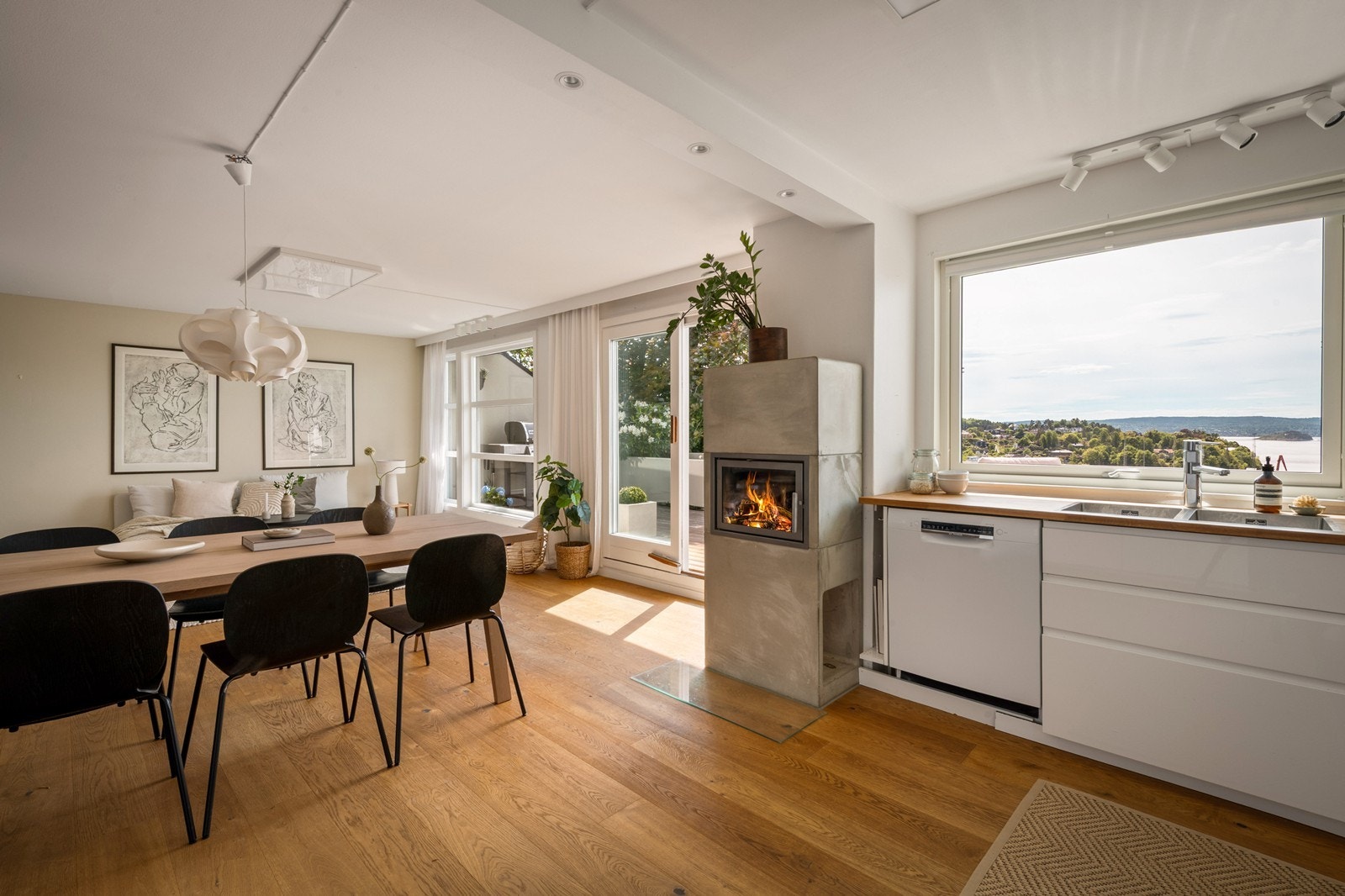Lys spisestue med peis og utsyn mot fjorden Galleribilde