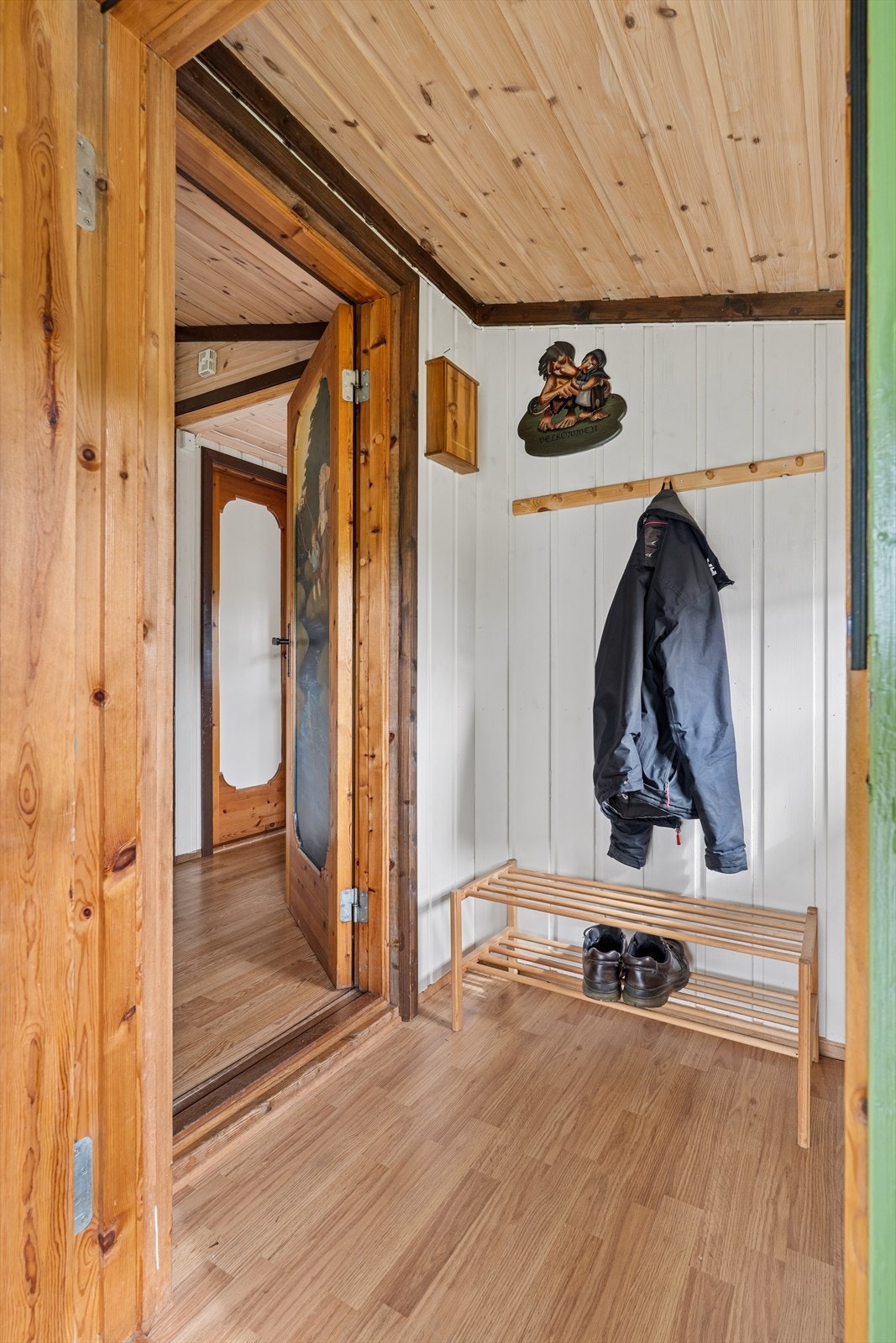Velkommen inn i en hyggelig entré med god plass til yttertøy og sko Galleribilde