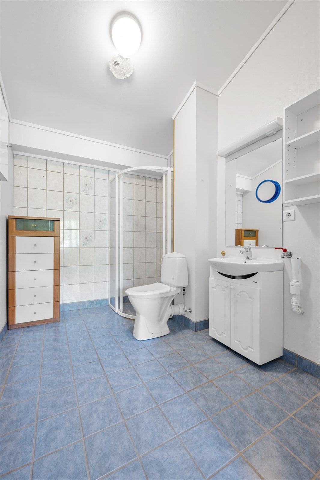 Badet har flislagt gulv med gulvvarme og opplegg for vaskemaskin. Galleribilde