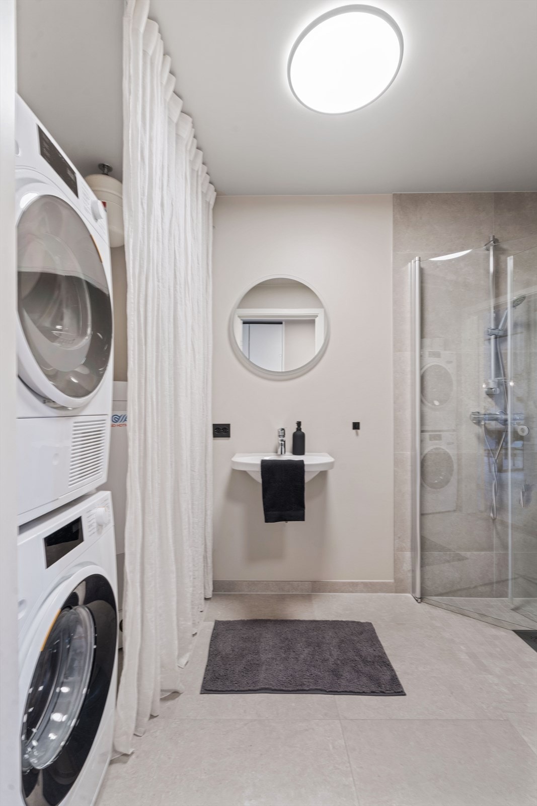 Badet i første etasje har flislagt gulv med gulvvarme og fliser i dusjsonen. Galleribilde
