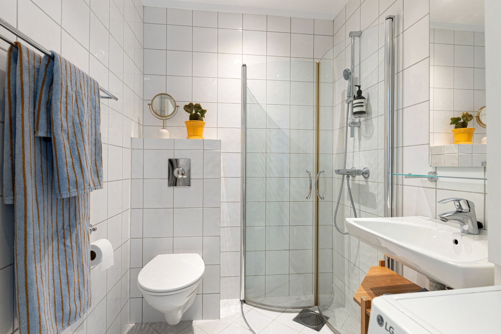 Tidløse materialvalg og praktisk innredning med vegghengt toalett og servant. Galleribilde