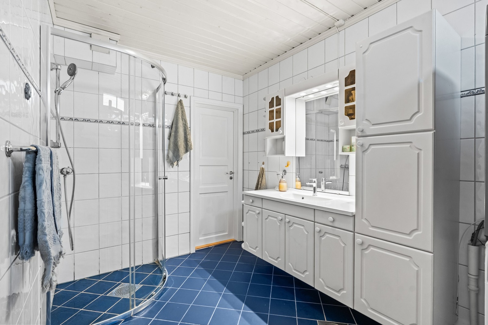 Badet er funksjonelt innredet med servant, dusjløsning og opplegg for vaskemaskin. Galleribilde