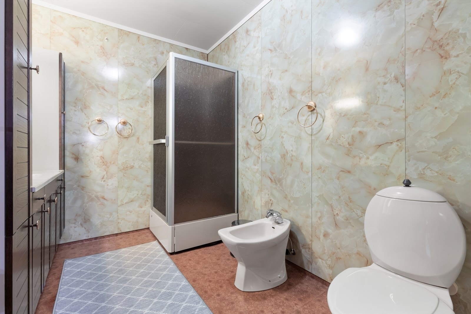 Bad i 1. etasje | badet har belegg på gulv og våtromsplater på vegg | rommet er utstyrt med stor baderomsinnredning, dusjkabinett, bidé og wc Galleribilde
