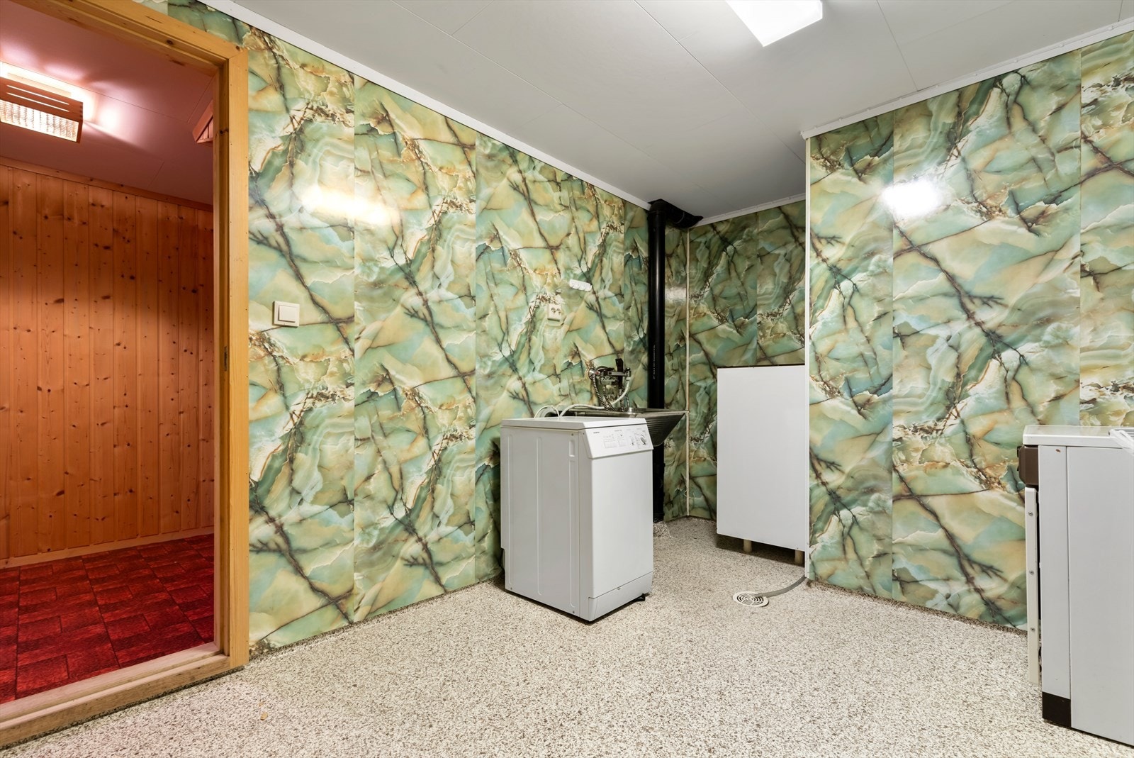 Vaskerom i kjeller | rommet har Terraflex med oppbrett på gulv og våtromsplater på vegger | rommet er utstyrt med rustfritt skyllekar og opplegg for vaskemaskin Galleribilde
