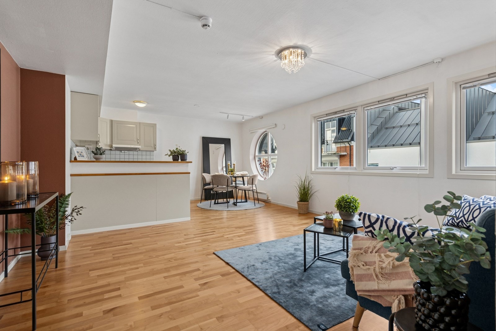 Det er en åpen og luftig stue/ kjøkkenløsning | Parkettgulv | Unikt, sirkulært vindu som tilfører karakter. Galleribilde