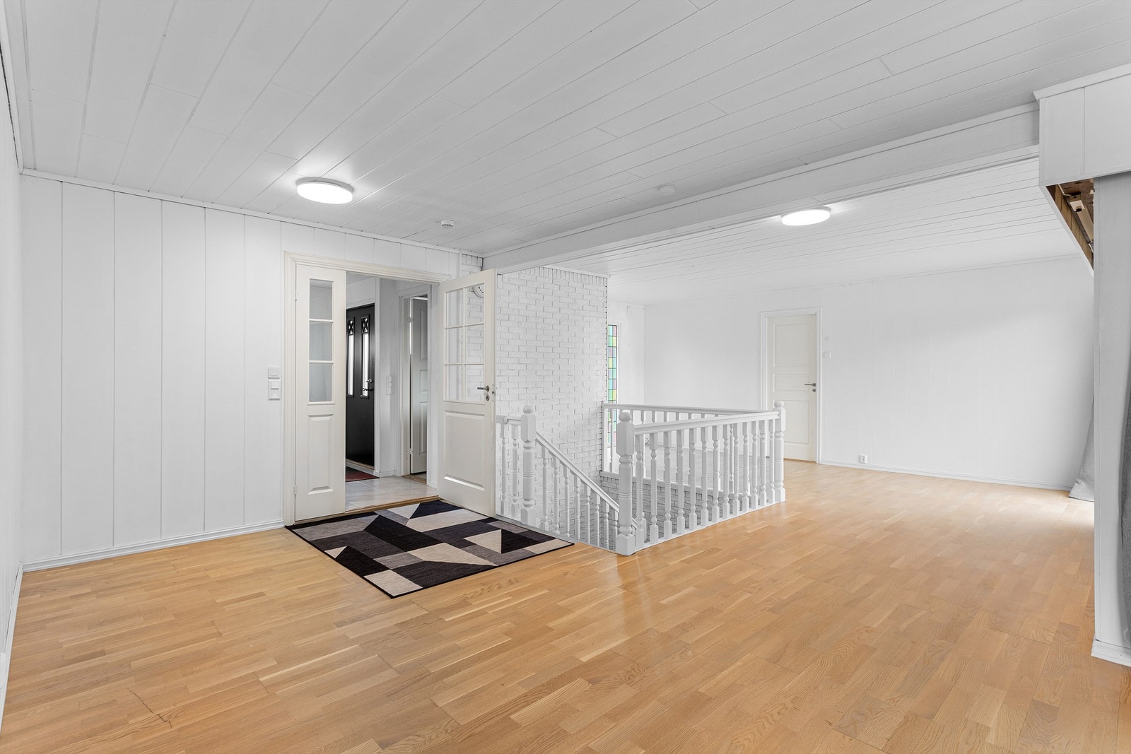 Lys og åpen hall som binder sammen boligens ulike soner i hovedetasjen. Galleribilde
