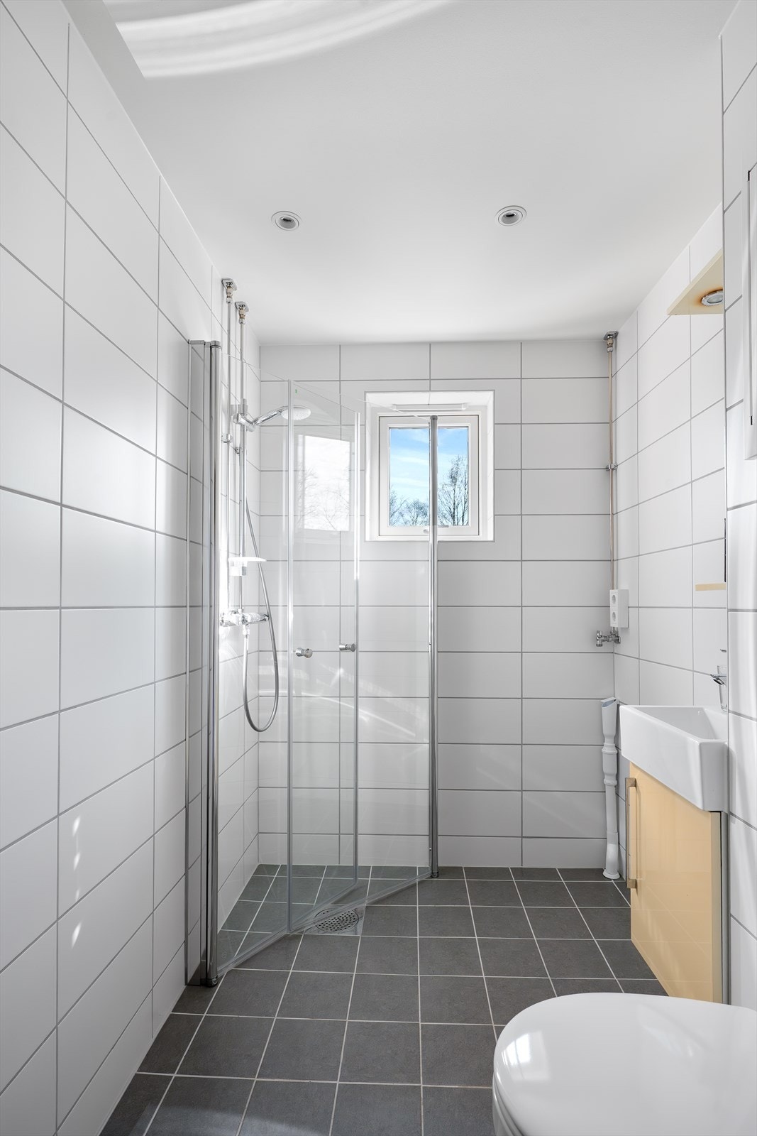 Badet har dusjhjørne med innfellbare dører og opplegg for vaskemaskin. Galleribilde