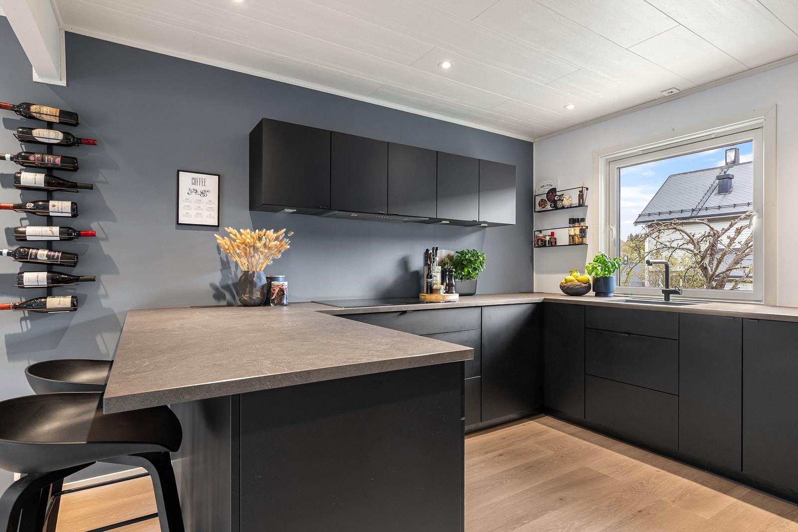 Kjøkkenet fra Kvik har mørke, matte fronter i U-form med en frittstående kjøkkenøy som fungerer som bardisk mot spiseplassen. Innredningen er med glatte fronter og laminat benkeplate med planlimt vaskekum. Galleribilde
