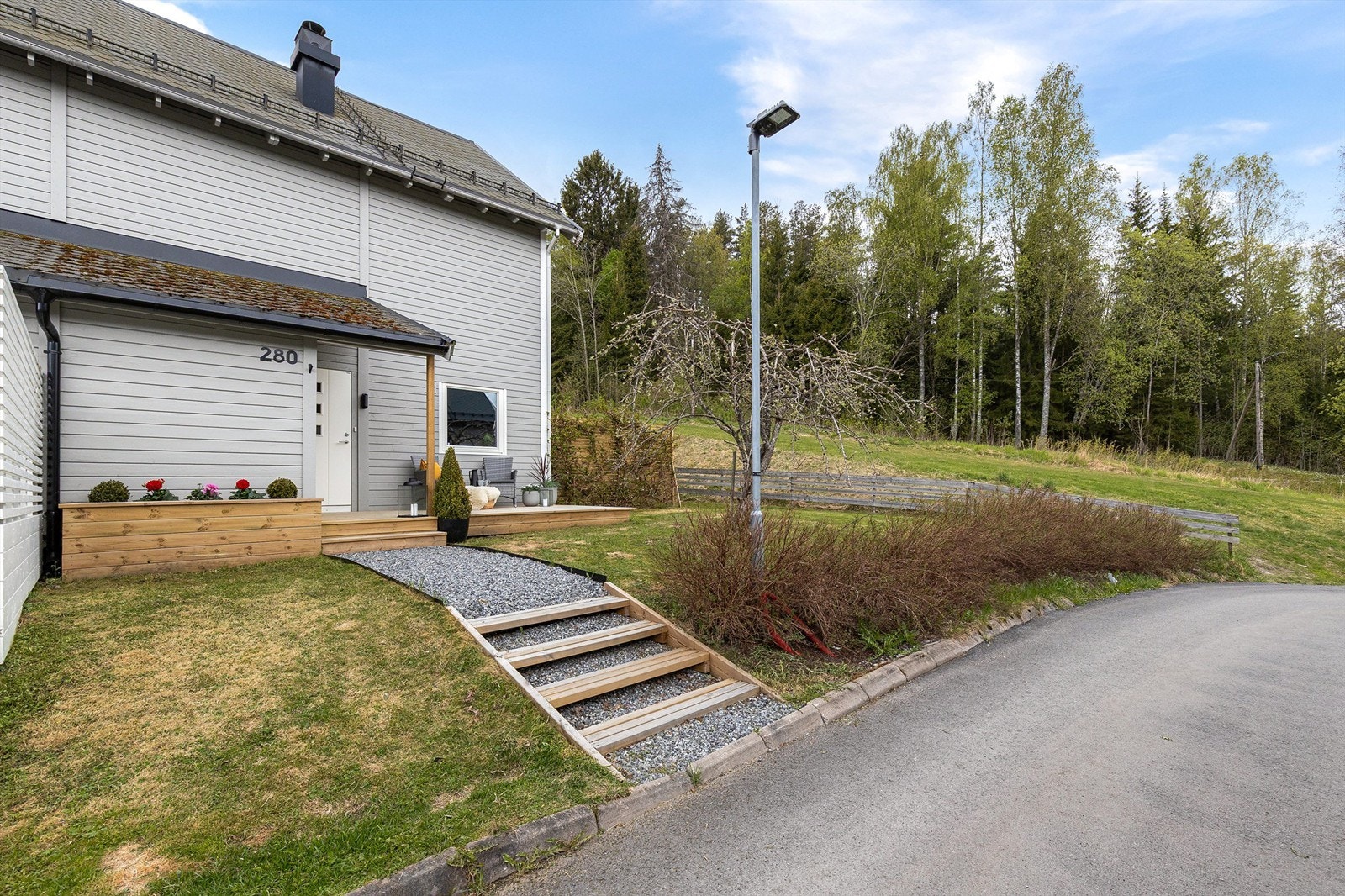 Pent opparbeidet inngangsparti. Parkeringsplass med elbillader medfølger. Galleribilde