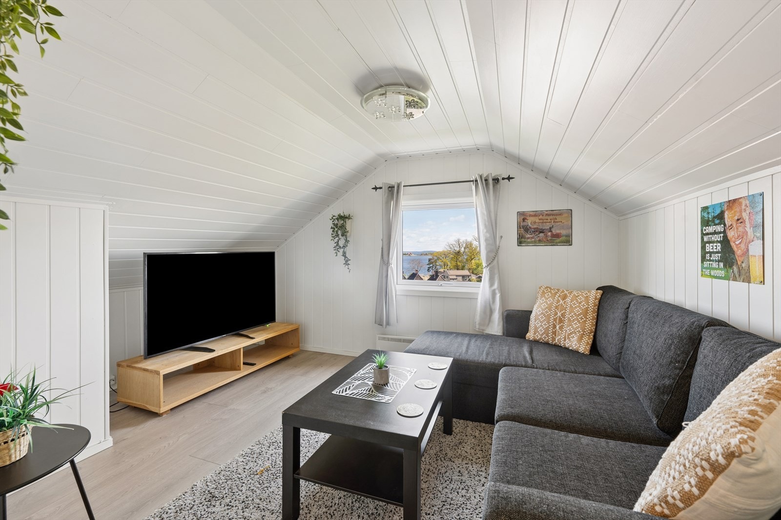 Loftstue innredet i 2022 med plass til sofagruppe og TV-møblement. Rommet er ikke godkjent for varig opphold, se mer pkt. ferdigattest. Galleribilde