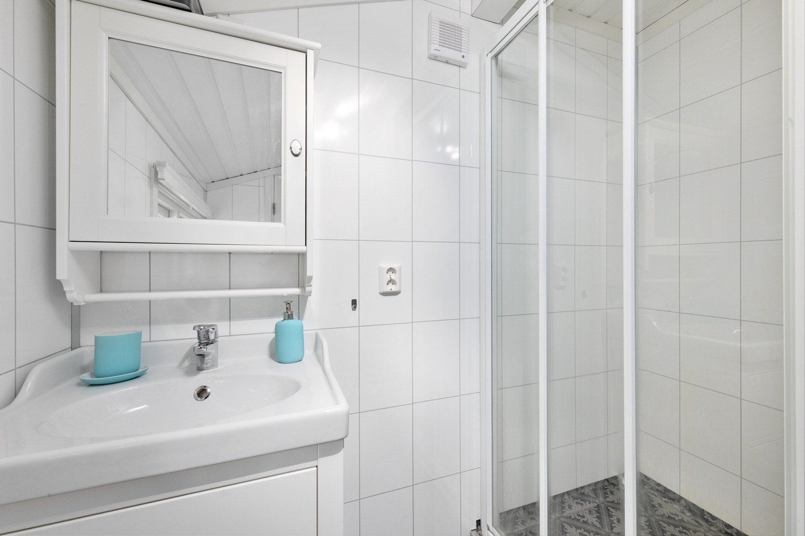 Vegger kledd med laminat våtromsplater og servantinnredning med speil. Galleribilde