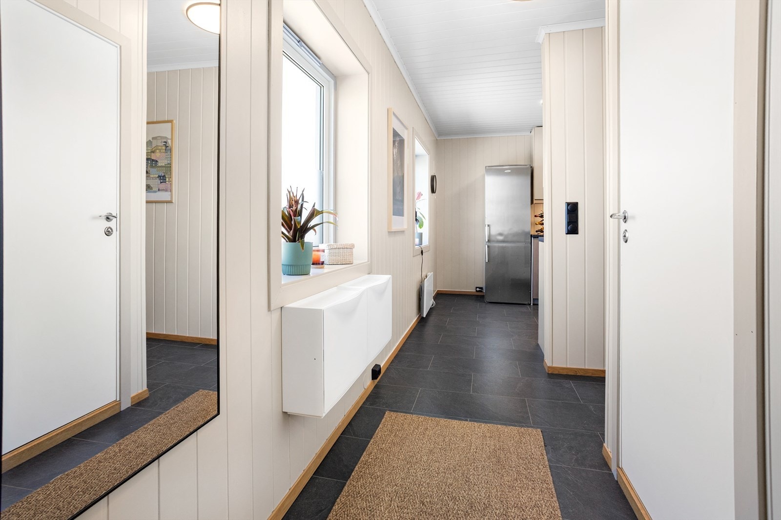 Vel inne ankommer man leilighetens entré, som fremstår lys og romslig med god plass til oppheng av yttertøy. Galleribilde