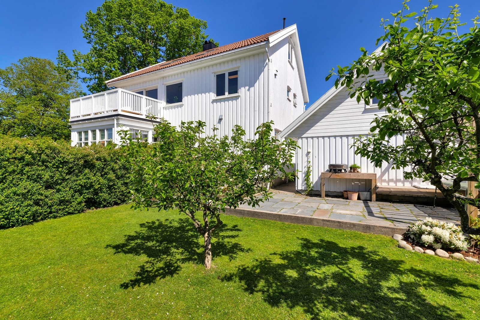 Den private hagen er pent opparbeidet med skiferplatting, pergola og plen. Meget solrik tomt som grenser til parken. Galleribilde