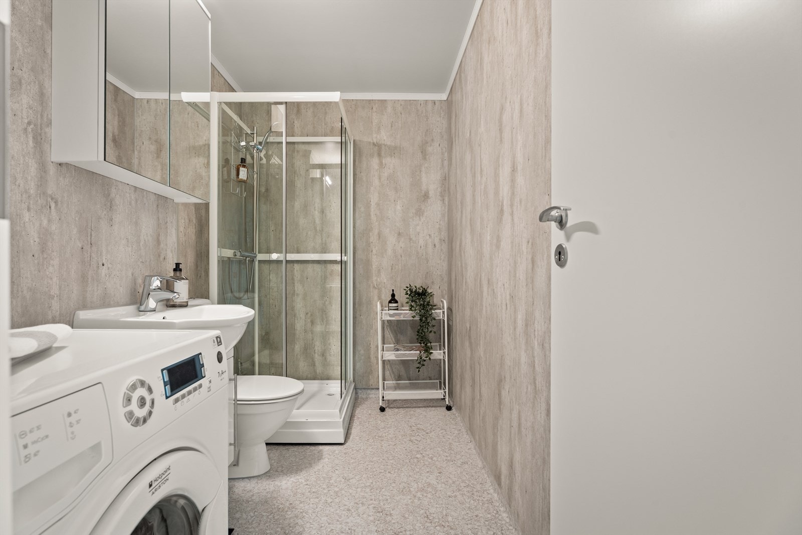Badet er utstyrt med dusjkabinett, servantskap og har opplegg for vaskemaskin. Galleribilde