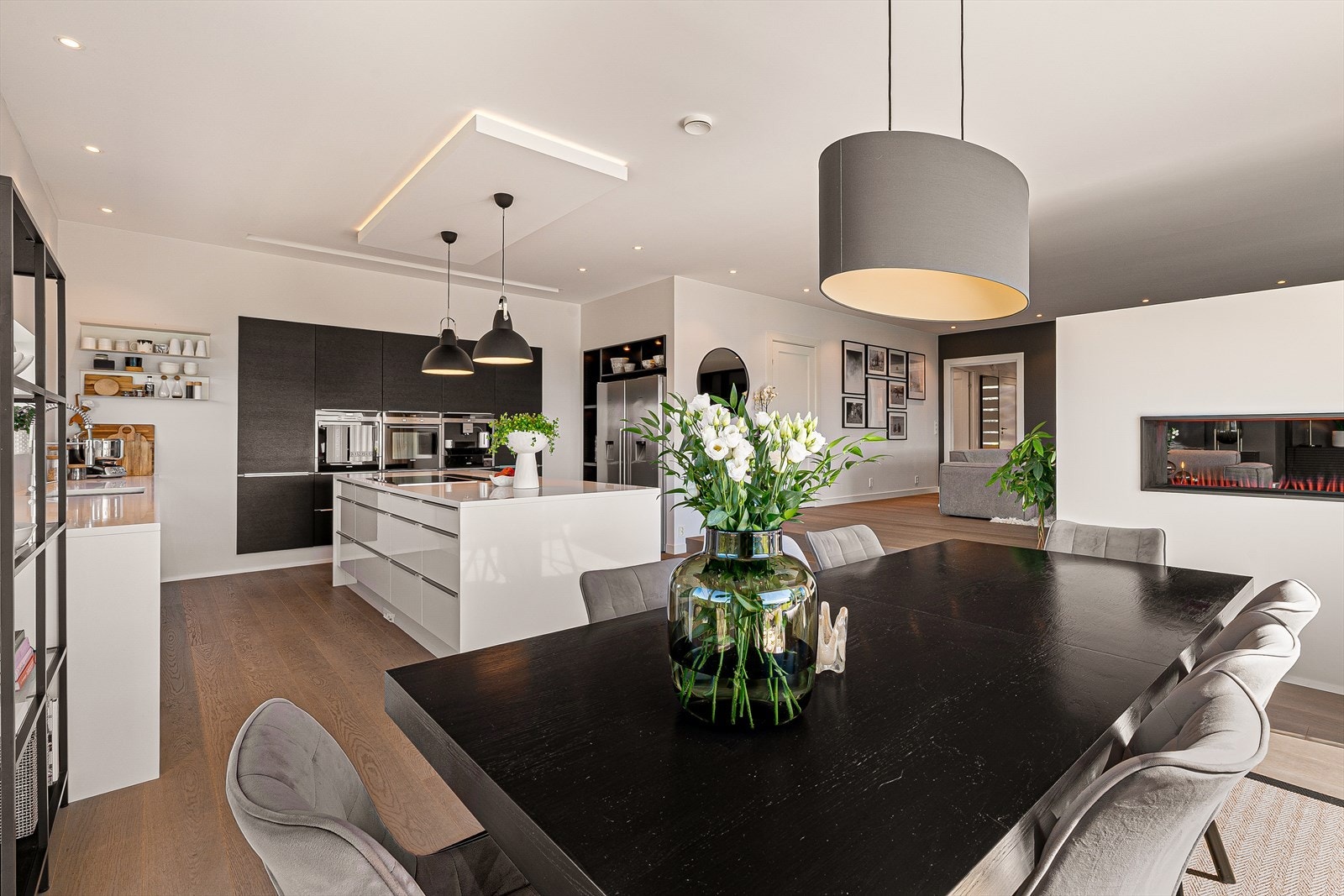 Kjøkkenet holder en eksklusiv utførelse med glatte fronter, benkeplate i Silestone og en stor kjøkkenøy med sitteplasser og rikelig med oppbevaringsplass. Galleribilde