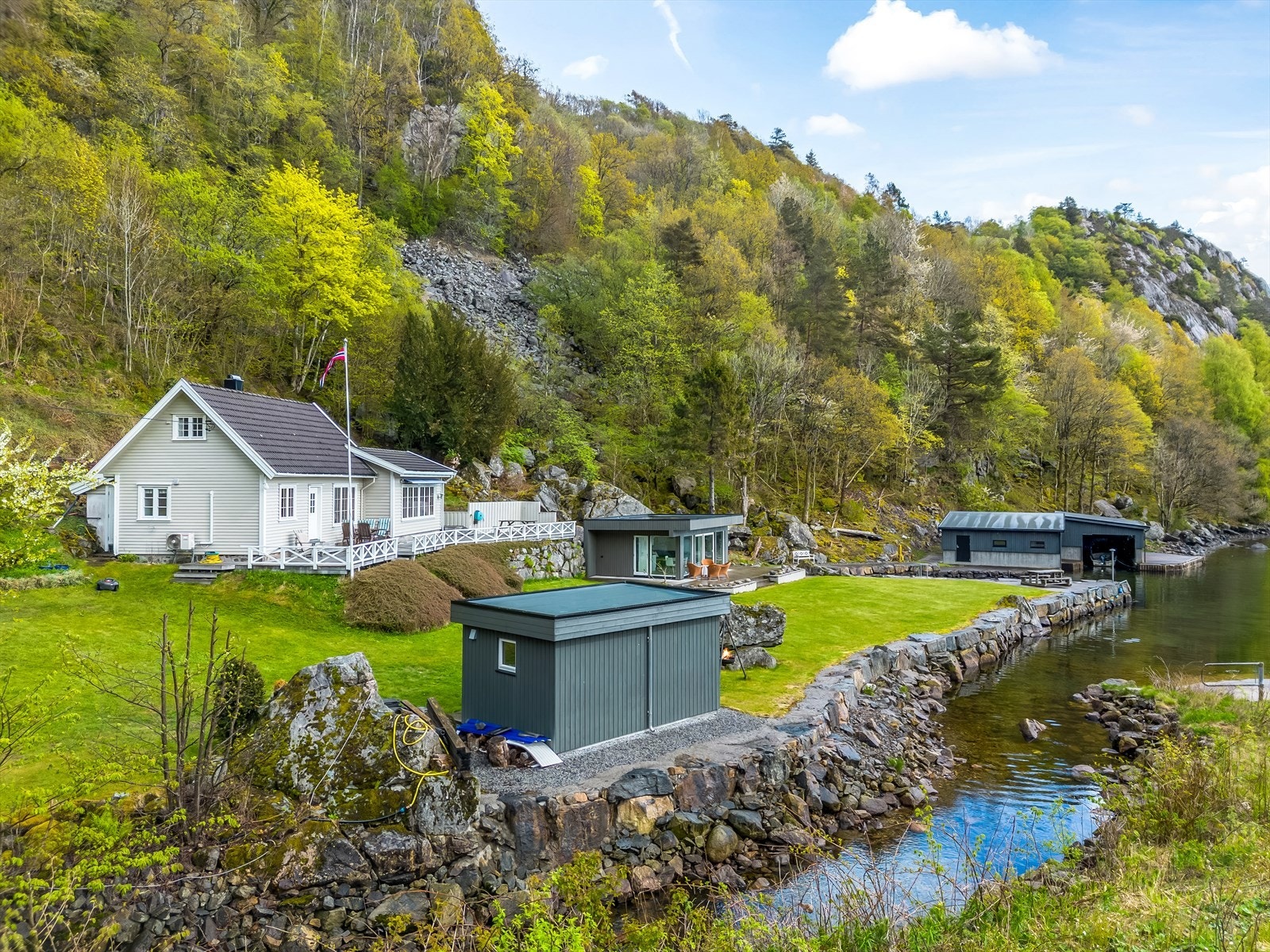 En sjelden strandeiendom med lang strandlinje, egen sandstrand, hytte, anneks og to båthus. Galleribilde