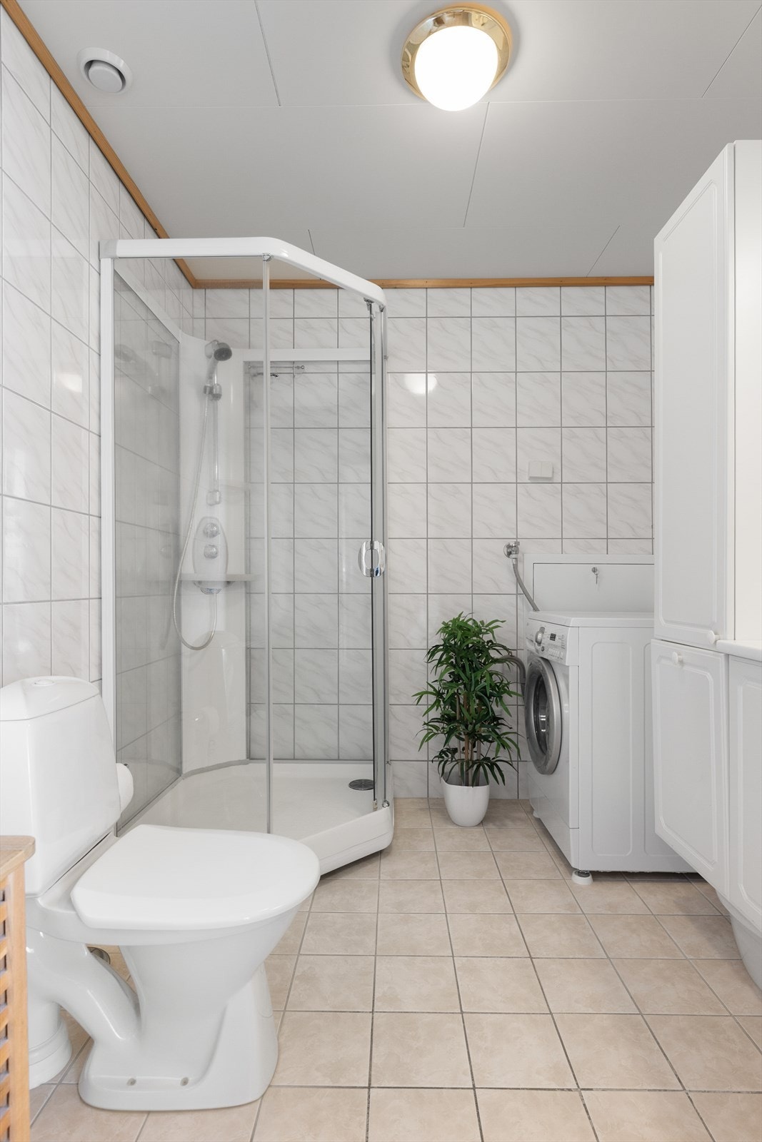 Badet er innredet med dusjkabinett, toalett og har opplegg for vaskemaskin. Galleribilde