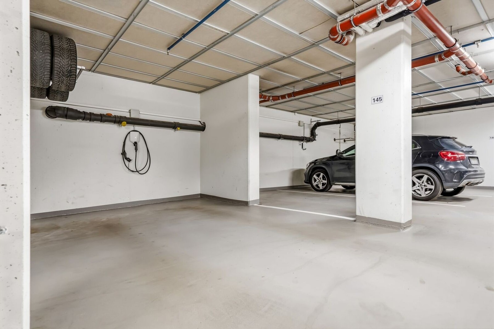 Med leiligheten medfølger biloppstillingsplass i garasjeanlegg. Her er det montert lader for el-bil, og hjuloppbevaring. Plassen har ekstra bredde, og det er ingen biler som parkerer helt inntil. Galleribilde