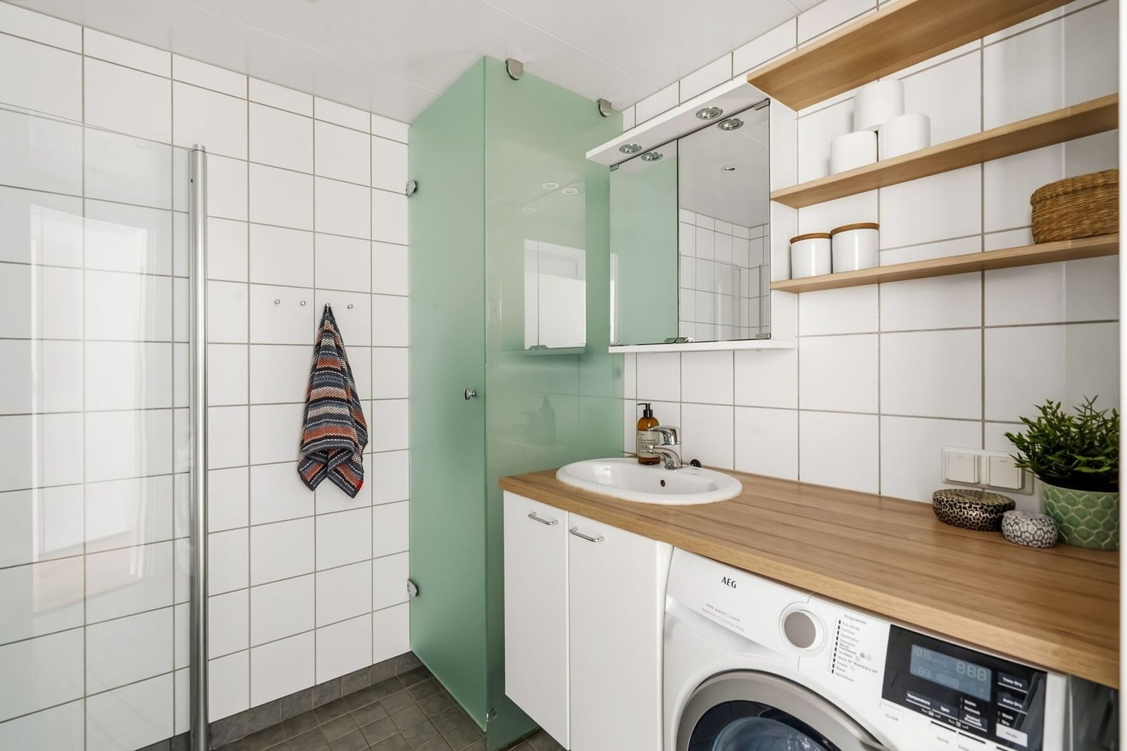 Badet til hoveddelen er et stor delikat baderom med lyse og tiltalende flis- og materialvalg. Galleribilde