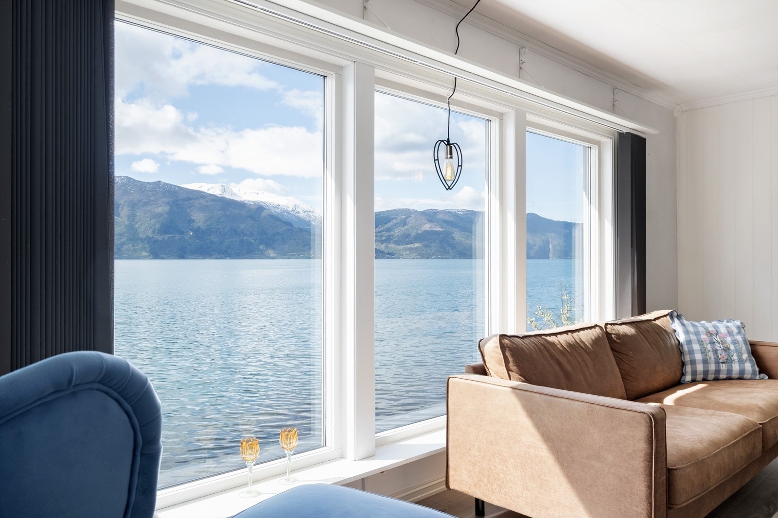 Store vindauger mot sør tek den unike nærleiken til fjorden inn i opphaldsrommet. Alle vindauga i huset er skifta ut frå 2009 og framover. Galleribilde