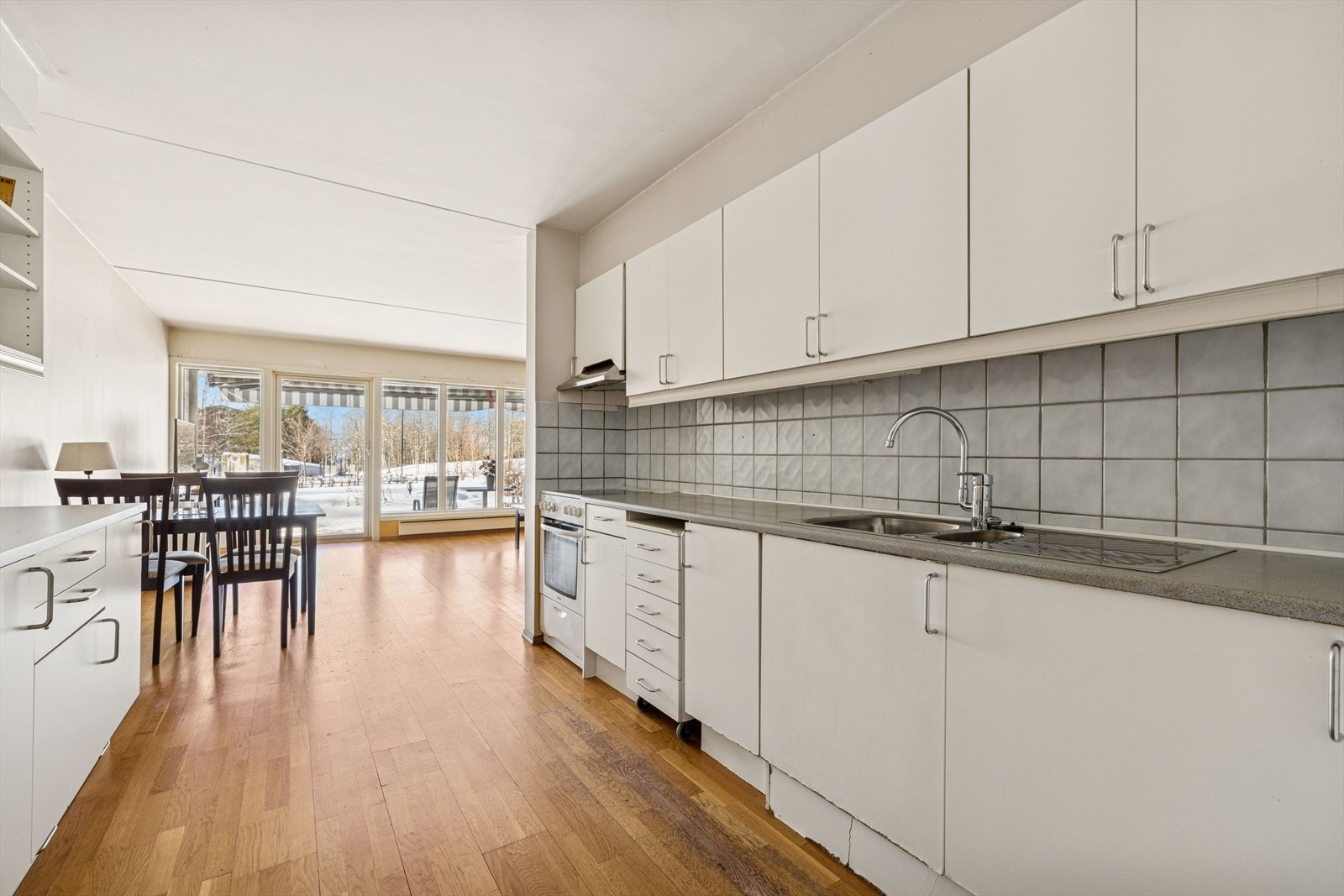 Kjøkkeninnredningen med under-/overskap og slette fronter. Benkeplater av laminat med nedfelt kum i rustfritt stål og ett-greps blandebatteri. Galleribilde