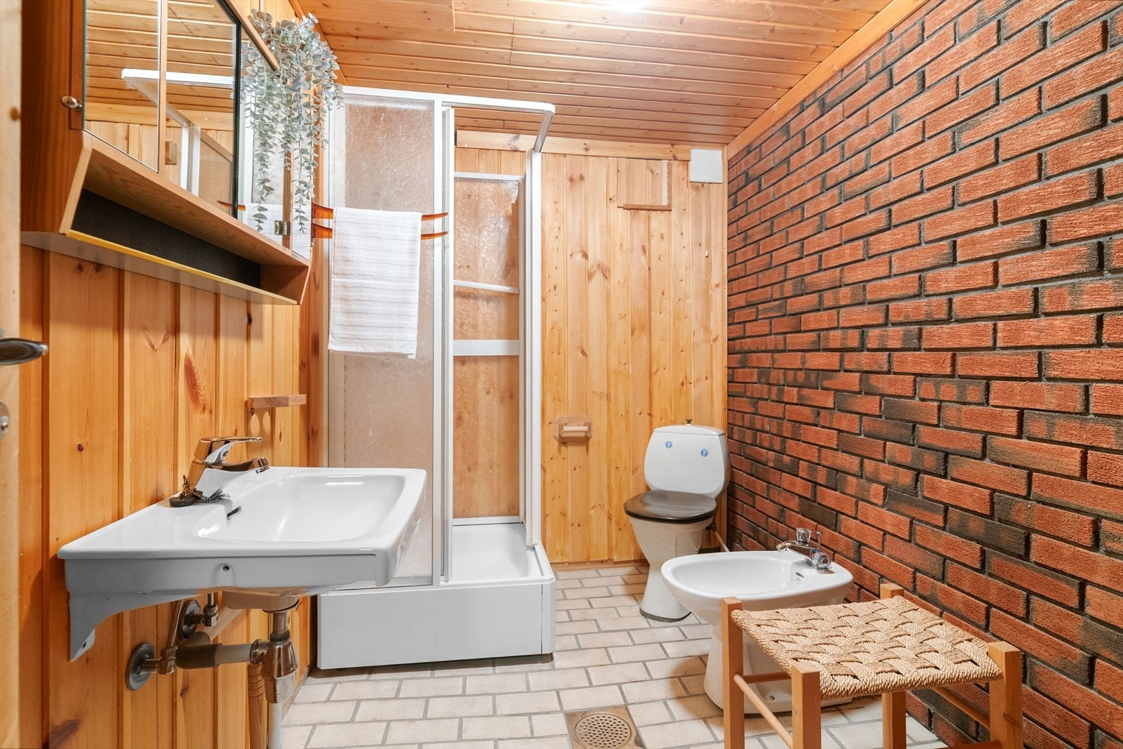 Badet i kjelleren har flislagt gulv med varmekabler, toalett, servant og dusjkabinett. Galleribilde