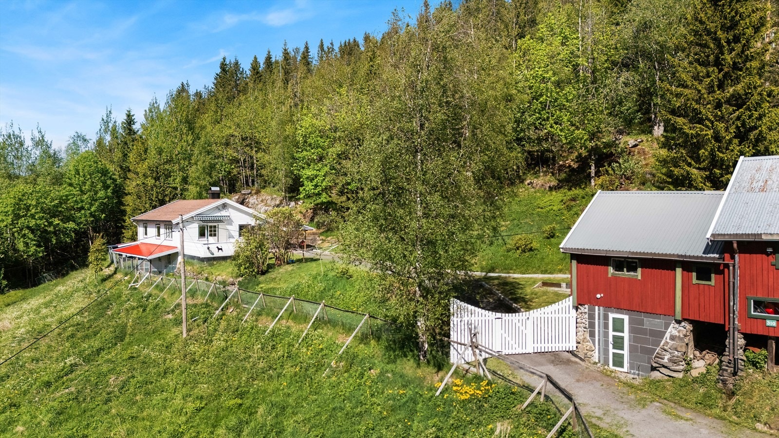 Eneboligen og låven sett fra avstand, som viser den landlige beliggenheten. Galleribilde