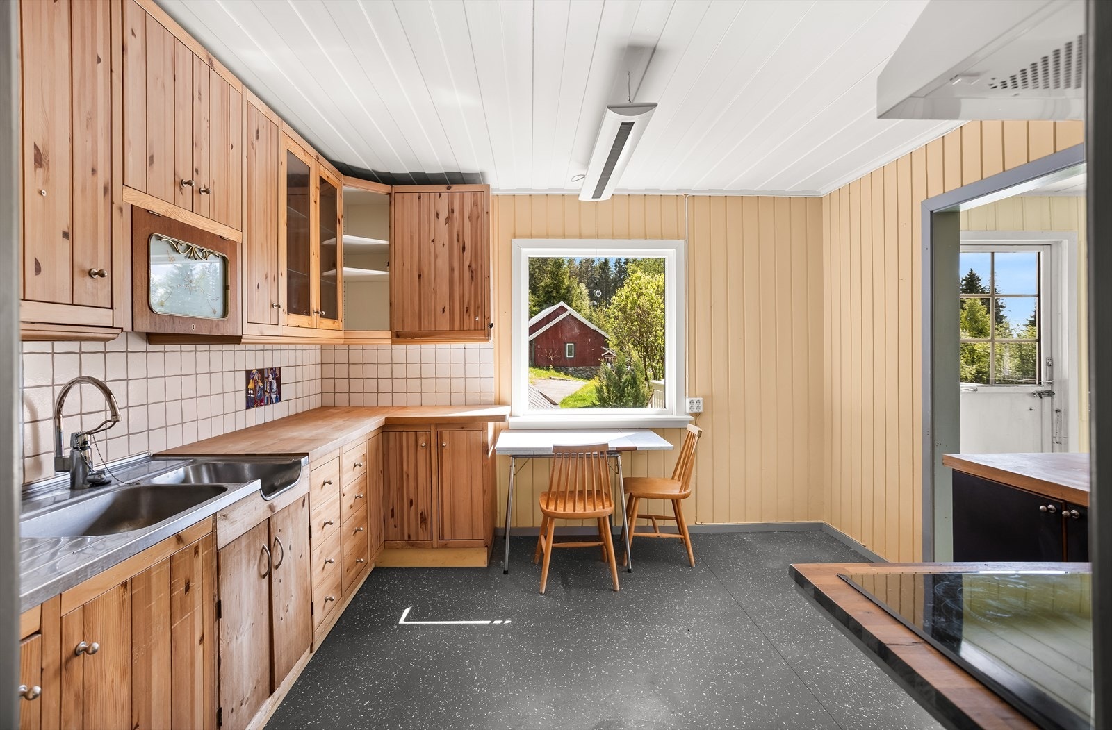 Kjøkkeninnredning med profilerte fronter, benkeplate i heltre og fliser over benken. Galleribilde