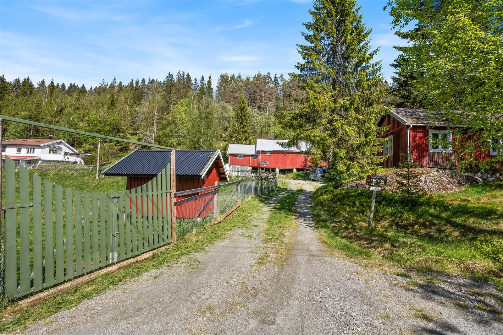 Innkjøring til eiendommen. Gårdsplassen er asfaltert. Galleribilde