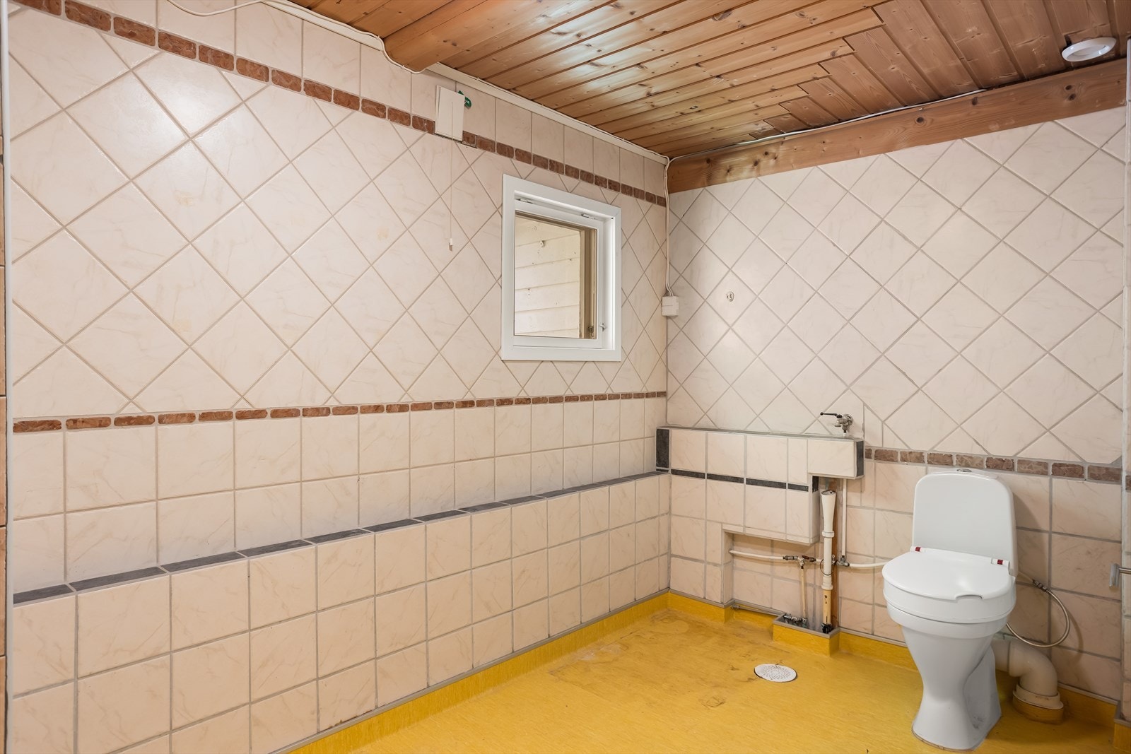 Gulvmontert toalett. Rommet ventileres med en elektrisk styrt avtrekksvifte. Galleribilde