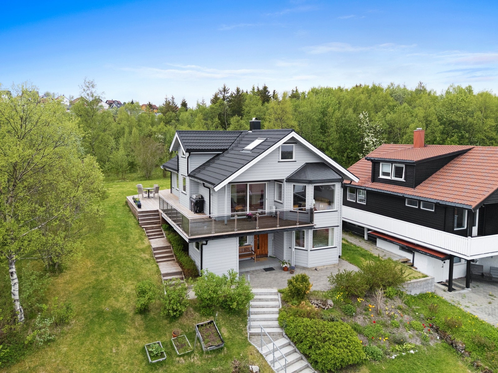 Stor terrasse med utgang fra stuen og kjøkkenet, samt en hage som grenser mot friområde. Galleribilde