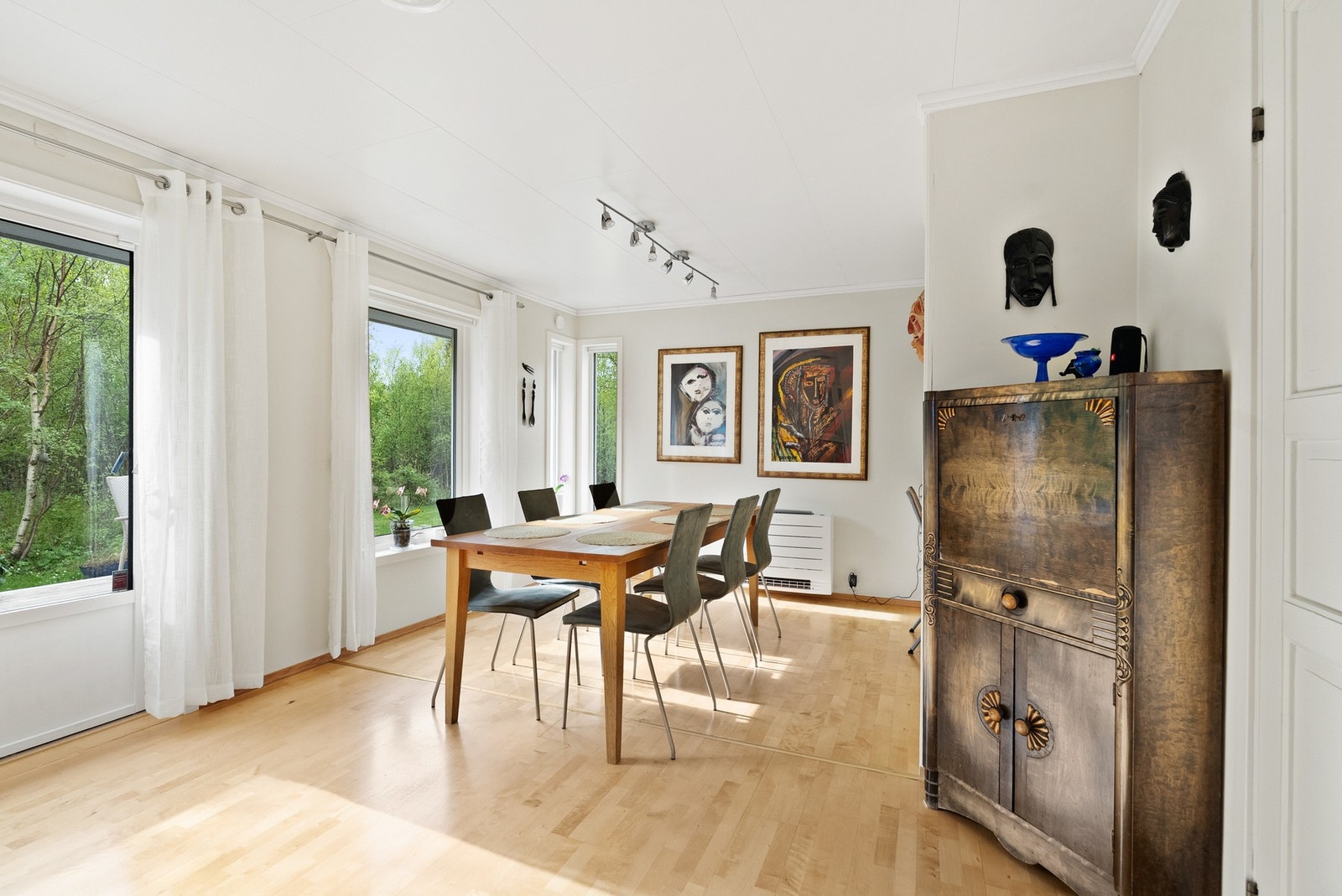 Store vinduer i spisestuen gir godt med naturlig lys og utsikt mot hagen, og dør ut til terrassen. Galleribilde