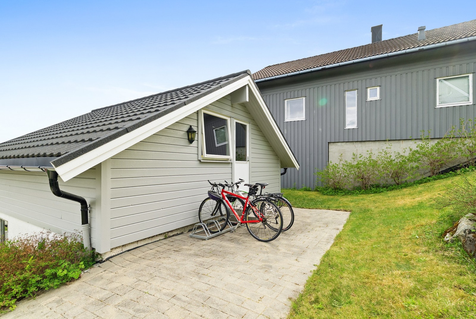 Frittstående dobbelgarasje med asfaltert innkjørsel og sykkelparkering. Galleribilde