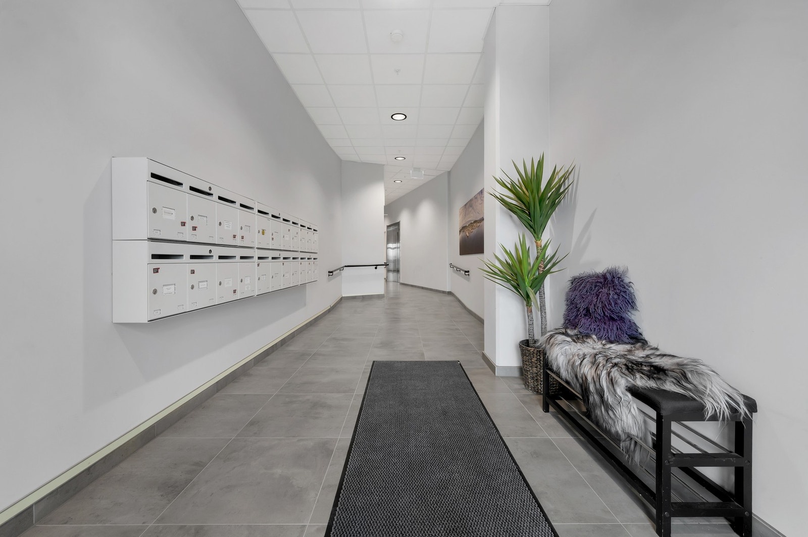 Pent og ryddig inngangsparti med postkasser og adkomst til heis. Galleribilde
