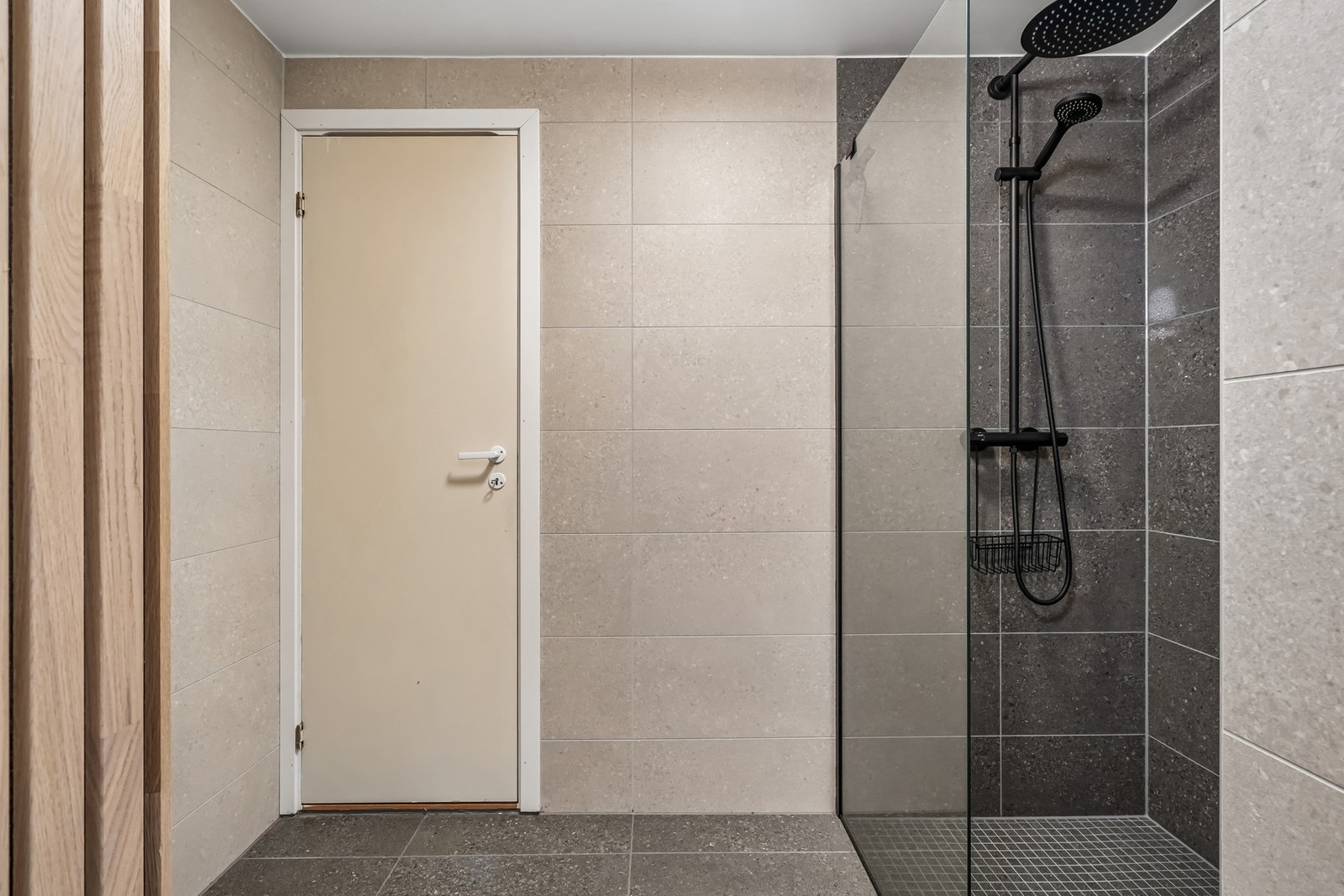 Helfliset bad med et moderne uttrykk, dekorativ spilevegg og elektriske varmekabler installert i 2025. (Badet er opprinnelig byggemeldt som bod - søknadspliktig bruksendring). Galleribilde