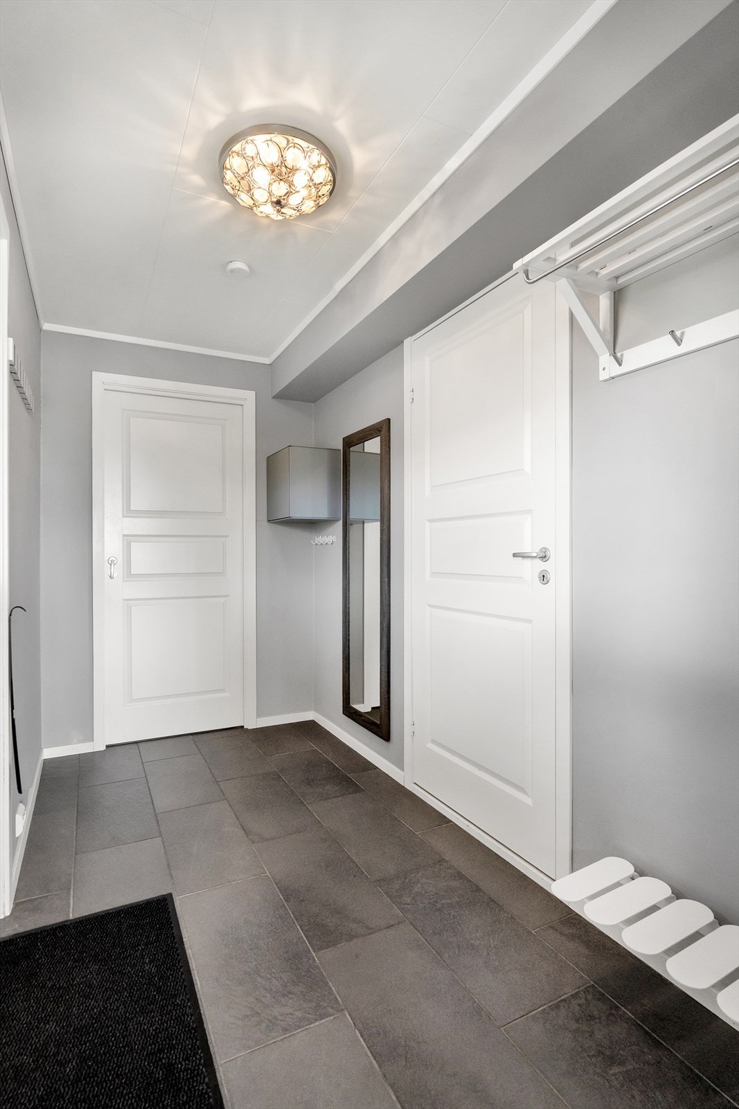 Velkommen inn! Entrè med flislagt gulv og gulvvarme, samt plass til garderobeløsninger for både oppheng og oppbevaring av yttertøy og sko. Galleribilde