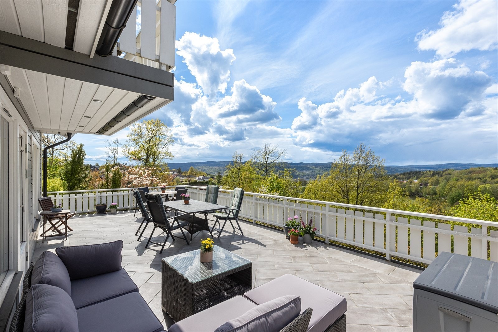 Stor og solrik flislagt terrasse utenfor stuen i 1. etasje. Galleribilde