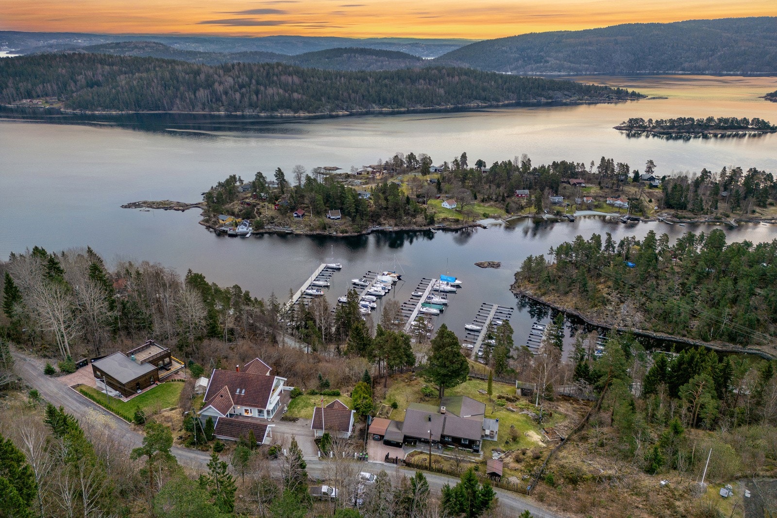 Dronefoto som viser at båthavnen er rett på nedsiden av eiendommen Galleribilde