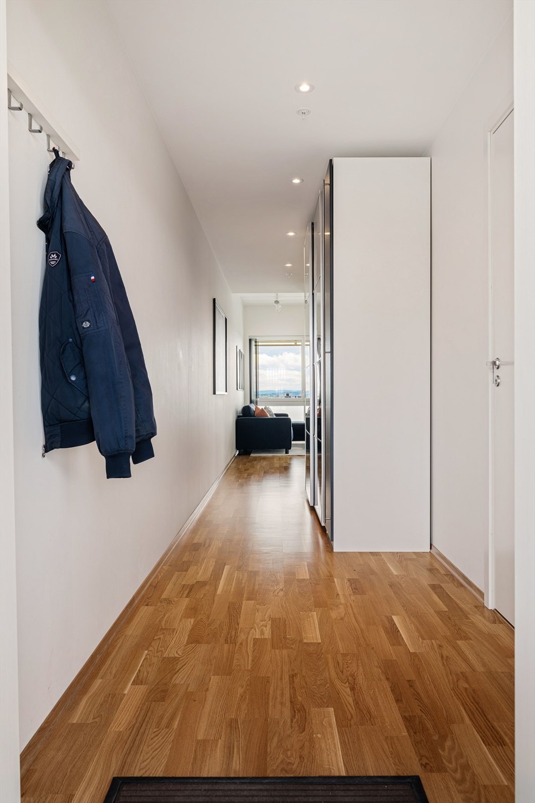 Gangen er innredet med en romslig skyvedørsgarderobe som gir gode oppbevaringsmuligheter. Galleribilde