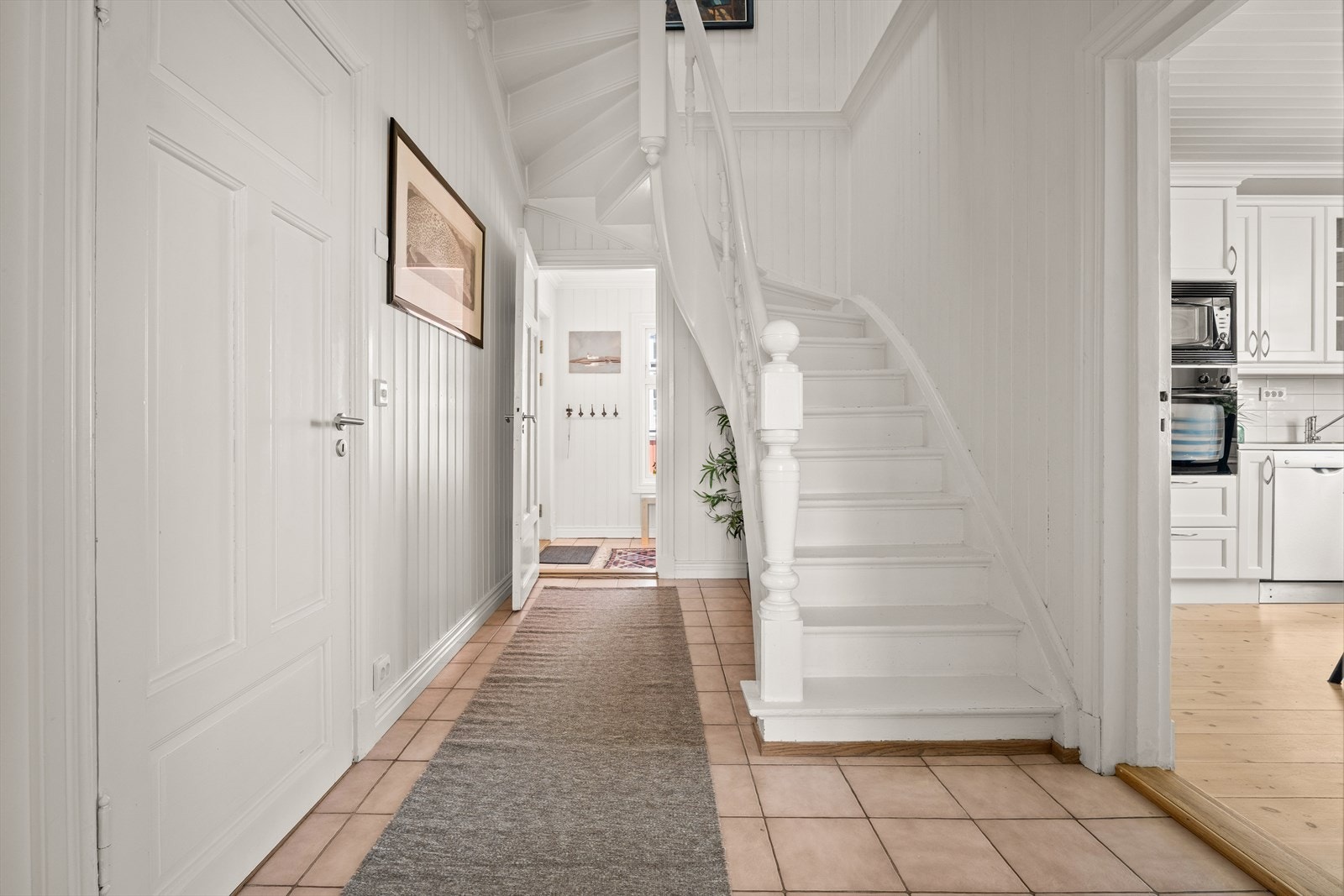 Hallen har en flott, tidstypisk tretrapp med brede trinn til andre etasje og en luft-til-luft varmepumpe fra 2018. Galleribilde