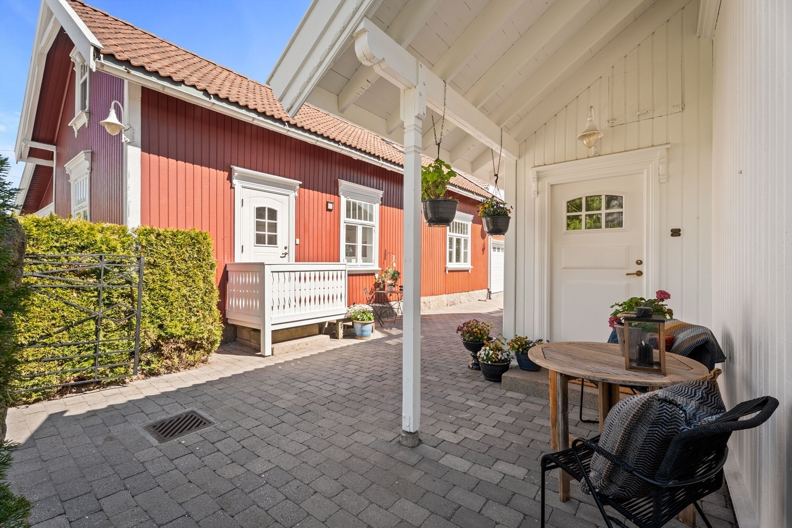 Overbygget inngangsparti til hovedhuset, med plass for en liten sittegruppe. Galleribilde