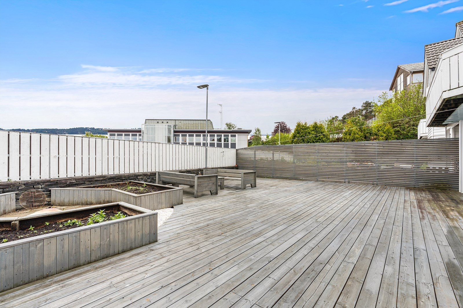 Uteplassen er tilrettelagt med soner for beplanting i store blomsterkasser. Galleribilde