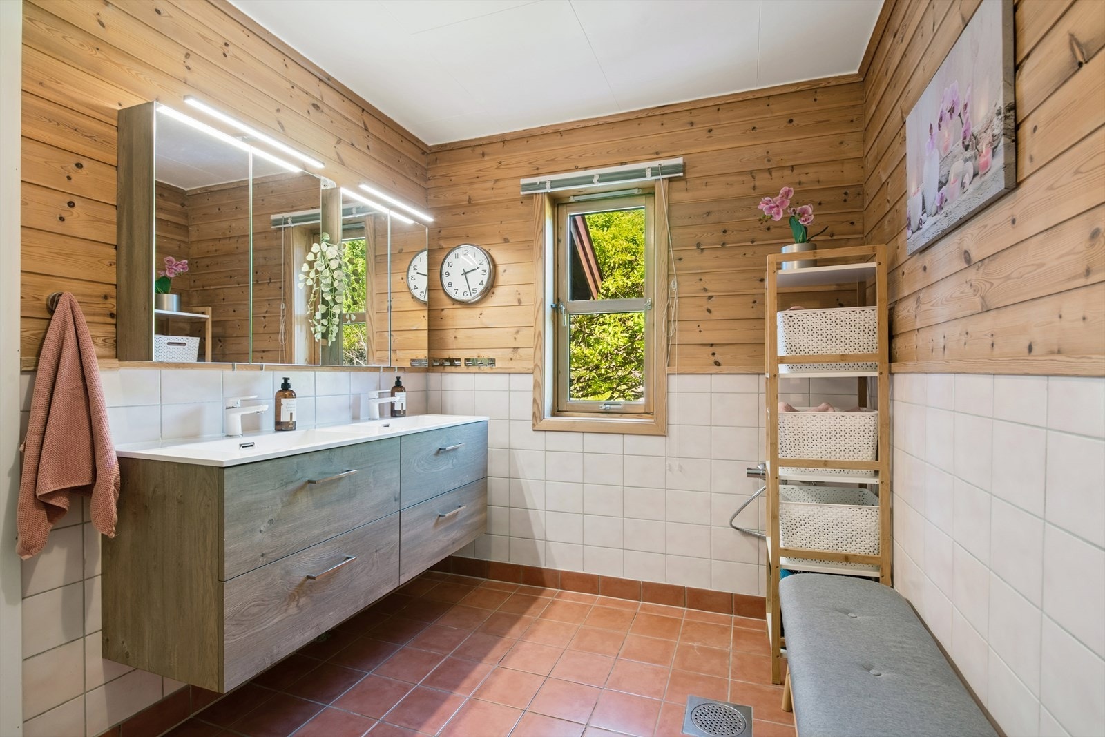Badet i 1.etasje har fliser på gulv og vegger med flis og panel. Innredningen med to nedfelte servanter er fra 2020. Galleribilde