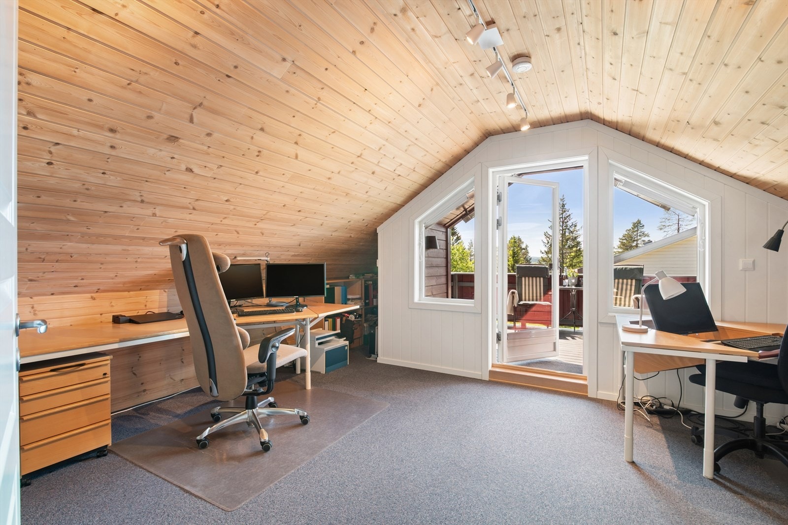 Et stort kontor på loftet har god plass til arbeidsstasjon og direkte utgang til en sørvestvendt veranda. Galleribilde
